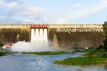 Khun Dan Prakarn Chon Dam has opening the gate for flowing the water in the morning with blue sky backgorund.