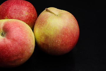 wet apples on a black background