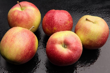 wet apples on a black background