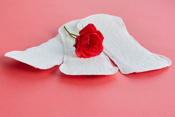 Sanitary napkins and flower on red background
