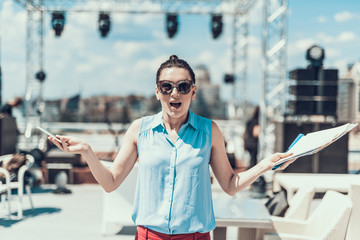 Portrait of surprised lady in modern sunglasses looking at camera and gesticulating hands. She...