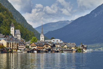 Hallstatt village landscape with old buildings reflected in blue lake.