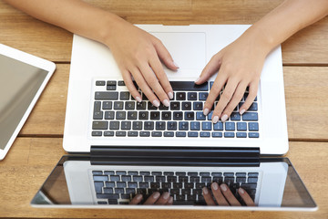 Fototapeta na wymiar Close-up of woman typing on laptop