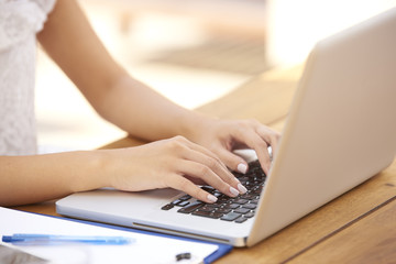 Close-up of woman typing on laptop