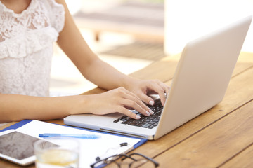 Close-up of woman typing on laptop