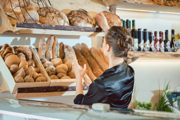 Shop assistant sorting bread to be sold in bakery shop