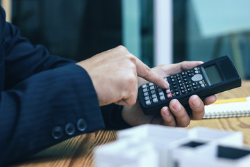 Businessman accountant using calculator and laptop for calculating finance on desk office. business financial accounting concept.