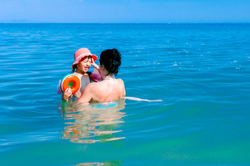 Girl is wearing inflatable armbands, learning to swim in the sea