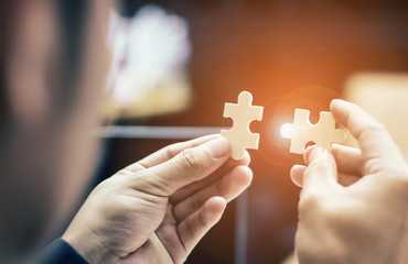 Business People hands trying to connect couple puzzle piece .one part of whole. symbol of association and connection. business strategy.Partnership SALES Team Collaborate with Competitors
