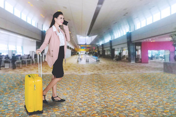 Beautiful entrepreneur with phone at airport