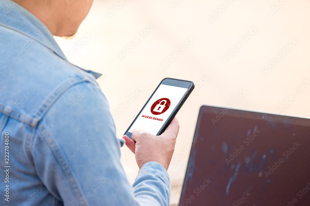 Poster protection security system concept. man holding smartphone with access denied text on screen.