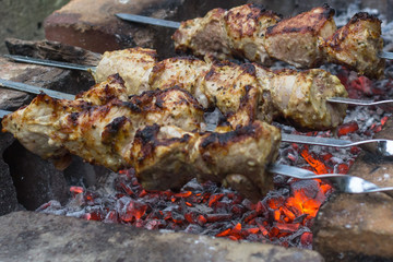 Shish kebab on fire. Meat for a barbecue. Grilled meat. Cooking on fire. Picnic in the forest by the fire. Chicken or grilled meat.