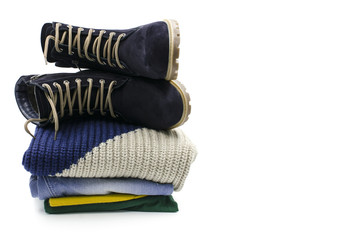 A pile of clothes with boots are on a white background
