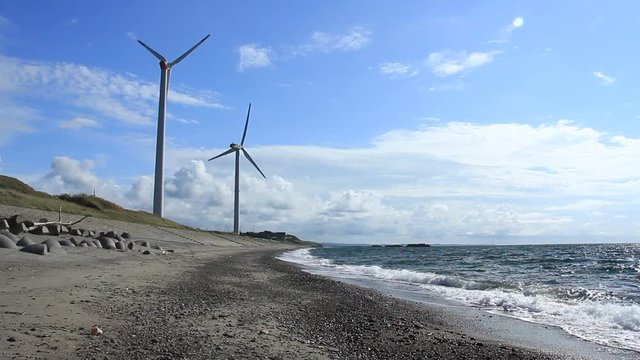 青空と海辺の風力発電