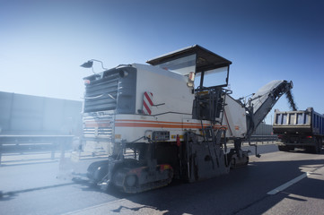 Road Construction on the highway with metal safety barrier. special machine removing the old asphalt