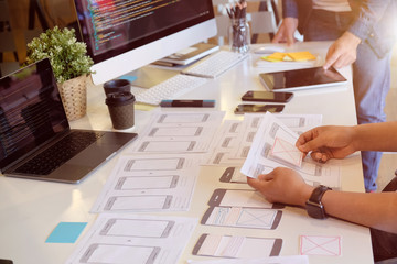 Team ux designer creative graphic planning application development a prototype smartphone layout.