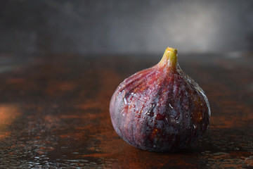 A very ripe blue fig on a dark background. Organic fruits. Healthy food