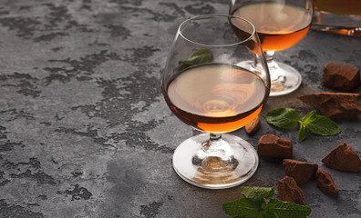 Two glasses with cognac, whiskey stones and almonds