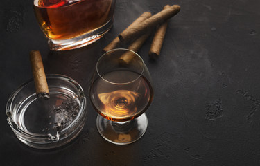 Two glasses with cognac, bottle and cigars