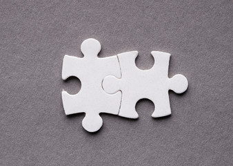Two interlocked puzzle pieces, teamwork concept