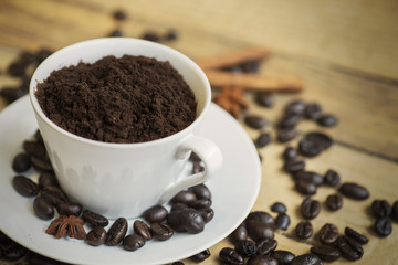 Ground coffee on the cup with coffee beans