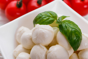 Mozzarella tomatoes and basil on a wooden rustic background