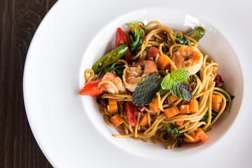 Spaghetti with spicy prawn in white dish.