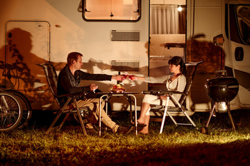Adult couple clinking glasses of wine. Family vacation travel RV, holiday trip in motorhome,...