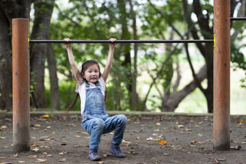 Fototapeta premium 鉄棒で遊ぶ女の子