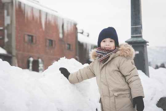 Happy Asian child playing in snow