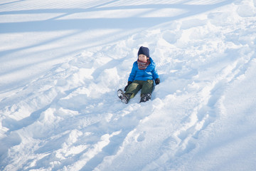 Fototapeta na wymiar Asian child sliding on snow