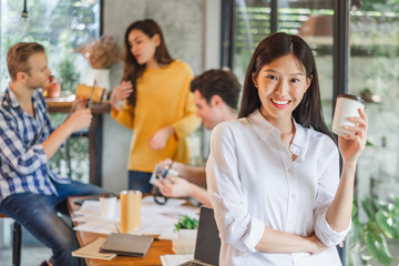 Portrait Asian business woman over group of young creative team working in cafe