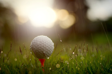 Golf ball with warm sunlight and raining at sunset