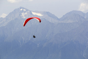 Paraplane on the blue sky background and mountains, leisure activity.