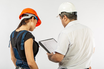 builders in hardhat or helmet discussing blueprints with tablet
