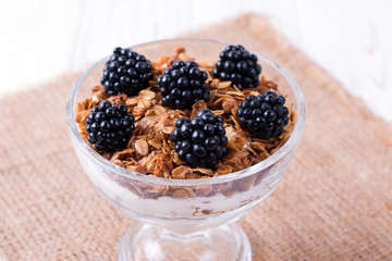 Healthy breakfast with homemade granola and berries, yogurt with muesli and blackberries