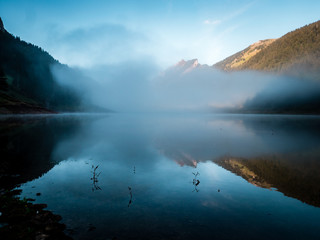 Fototapeta na wymiar fog covered mountain lake during sunrise morning switzerland