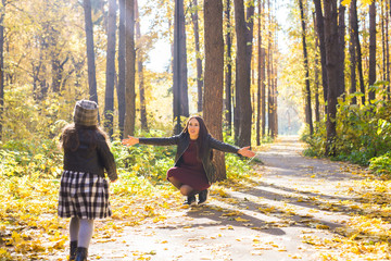 Mother and daughter have fun in autumn park