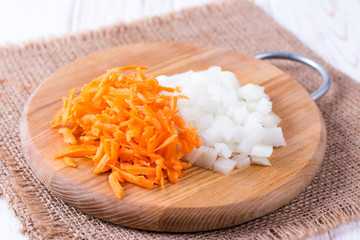 Onions and carrots chopped on a cutting board
