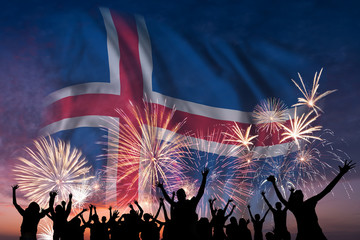 People are looking on fireworks and flag of Iceland