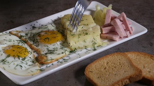 Eating Fried eggs with melted Romanian cheese called cas 