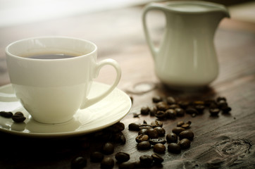 Coffee beans, glass and equipment for drinking coffee with warm light