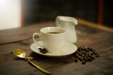 Coffee beans, glass and equipment for drinking coffee with warm light
