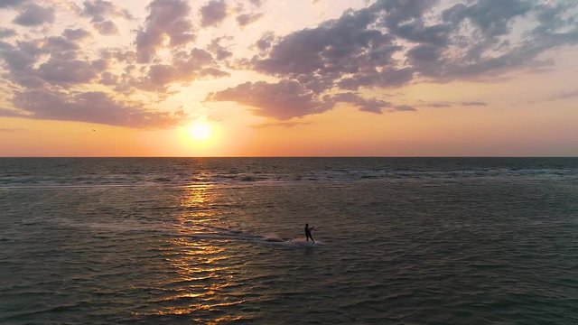 Beautiful sunset among the clouds, the kitesurfer sails to the side