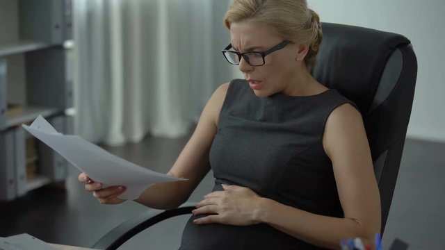 Pregnant office worker feeling strong pain in stomach, risk of misbirth, stress