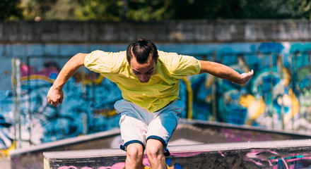 Obraz premium Sportive man running through obstacles in skatepark