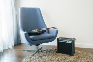 Gray armchair with guitar at corner of living room