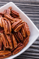 delicious pecan nuts on a rustic wooden background