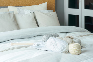 Modern interior bedroom with yarns and needle on bed