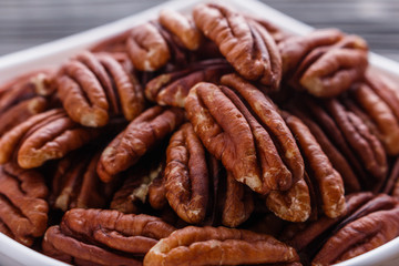 delicious pecan nuts on a rustic wooden background